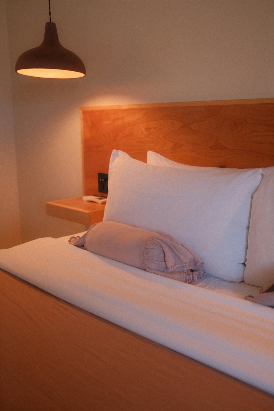 Modern bed with white pillows and a soft bedroom setting